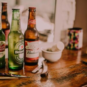 Three Assorted Beverage Bottles on Brown Wooden Table